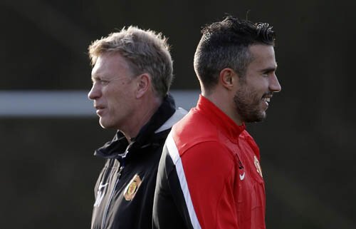 Manchester United's Van Persie walks past manager Moyes during a training session in Manchester