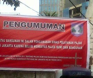 Bangunan menunggak PBB dipasangi papan pengumuman petugas Dinas Pelayanan Pajak.