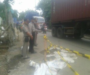 Petugas sedang melakukan pemasangan garis police line. (Wandi)