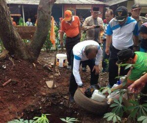 Walikota Jaksel, Tri Kurniadi mengubur ban bekas saat PSN di RT 04/07 Kelurahan Kebagusa, Pasar Minggu. (rachmi)