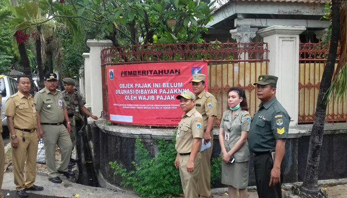 Camat Kelapa Gading dan Kepala UPPRD melakukan pemasangan stiker di rumah mewah. (wandi)