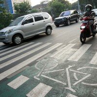 Pengendara kendaraan bermotor melintasi jalur sepeda di Jalan Melawai, Jakarta Selatan