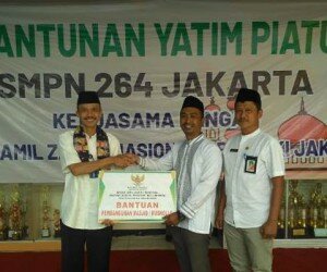 Koordinator Baznas (Bazis) Jakbar, Khairul menyerahkan bantuan Rp60 juta untuk siswa dan pembangunan mesjid kepada Kepala SMPN 264, Djumadi Subiantoro. (Rachmi)