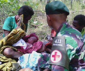 Prajurit Satgas Pamtas RI-PNG Yonif MR 411/PDW Kostrad saat membantu persalinan seorang warga di tengah hutan, Merauke, Papua. (penkostrad)