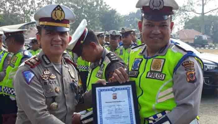 Kasatlantas Polres Purwakarta AKP Ricky Adi Pratama saat menyerahkan piagam penghargaan Operasi Patuh Lodaya 2019 kepada Aipda Juanda Barus. (dadan)