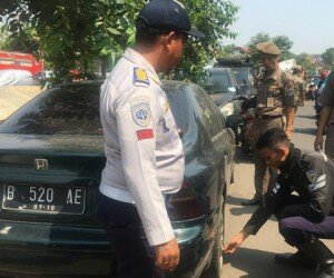 Petugas gabungan Kecamatan Palmerah, Jakbar menertibkan belasan kendaraan yang parkir sembarangan di kawasan Jln Inspeksi Kali Grogol. (Rachmi)