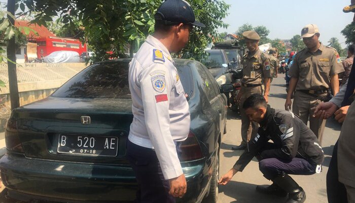 Petugas gabungan Kecamatan Palmerah, Jakbar menertibkan belasan kendaraan yang parkir sembarangan di kawasan Jln Inspeksi Kali Grogol. (Rachmi)