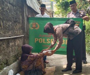 apolsek Beji Kompol Yenny bersama anggota membagikan nasi bungkus dalam program Jumat Barokah (angga)