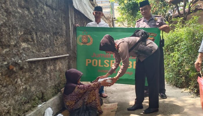 apolsek Beji Kompol Yenny bersama anggota membagikan nasi bungkus dalam program Jumat Barokah (angga)