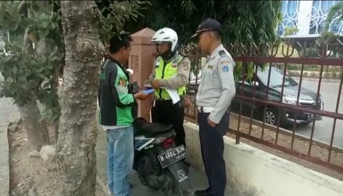 Petugas gabungan Sudishub Jakbar menilang tiga pengendara motor yang mangkal di trotoar di depan RS Soeharto Heerdjan di Jln Latumeten Raya, Grogol Petamburan. (Rachmi)