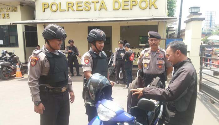 Kasat Sabara Polrestro Depok Kompol Subandi bersama anggota lengkap body face dan senjata laras panjang memeriksa tamu yang membuat laporan dengan mengecek tas gembok yang dibawa pos penjagaan. (angga)