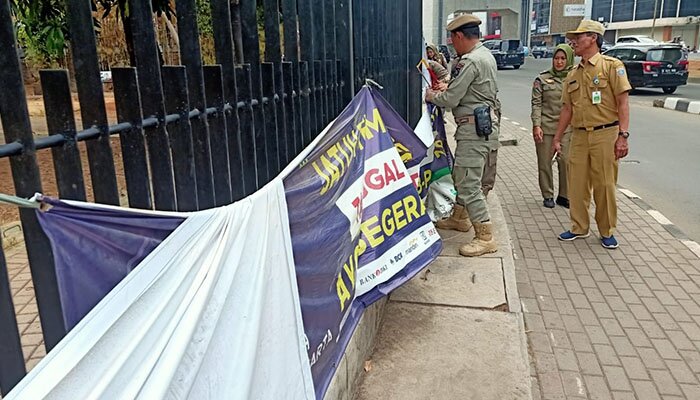 Petugas Satpol PP menertibkan spanduk liar di sepanjang Jl.Bouleverd Raya , Kelapa Gading. (deny)