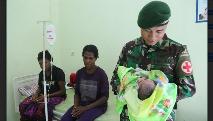 Anggota TNI bantu warga Papaua melahirkan.