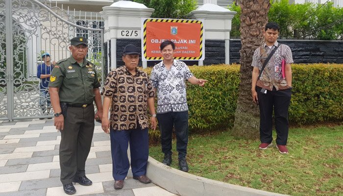 Petugas melakukan pemasangan stiker tunggak pajak terhadap salah satu rumah mewah di Sunter. (deny)