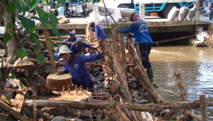 Sejumlah petugas sedang melakukan pemasangan cerucit disepanjang kali di Jalan Moch Kahfi II. (wandi)