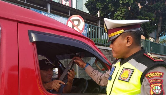 Kanit Kamsel Polres Metro Depok Iptu Nanang menegur pengemudi angkot yang tidak menggunakan sabuk pengamanan dalam operasi Penling. (angga)