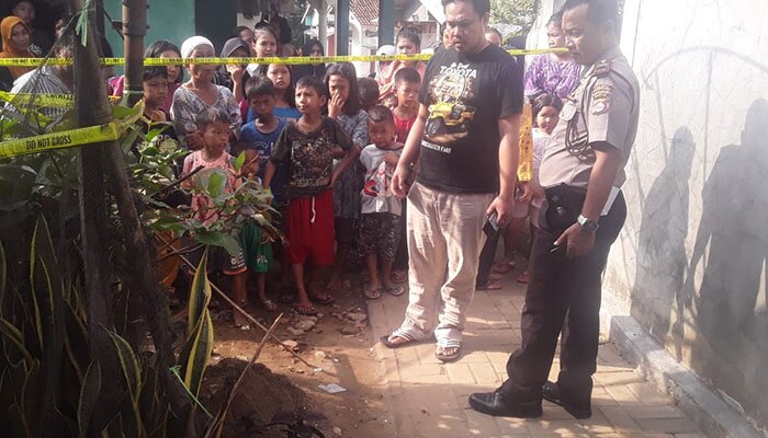 Petugas satreskrim tengah melakukan evakuasi mayat bayi terselip diantara tanaman.