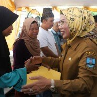 Bupati Serang Ratu Tatu Chasanah saat menyerahkan bantuan kepada pedagang korban kebakaran di halaman Kantor Kecamatan Baros. (haryono)