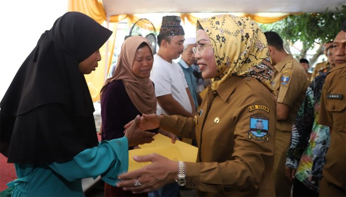 Bupati Serang Ratu Tatu Chasanah saat menyerahkan bantuan kepada pedagang korban kebakaran di halaman Kantor Kecamatan Baros. (haryono)