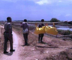 Petugas memikul kantong jenazah tanpa identitas dari muara Sungai Rambatan di Blok Waledan, Desa Lamarantarung, Kecamatan Cantigi, Indramayu, Jawa Barat, Selasa, (24/12/2019). (taryani)