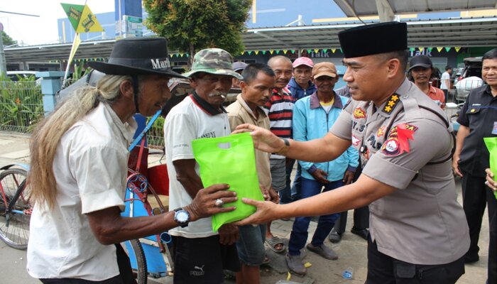 Kabid Humas Polda Banten Kombes Pol Edy Sumardi P saat membagikan bingkisan. (haryono)