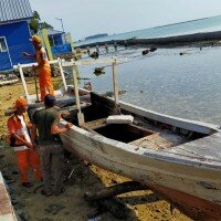 Petugas PPSU tengah menertibkan bangkai kapal milik nelayan di Pulau Panggang. (deny)
