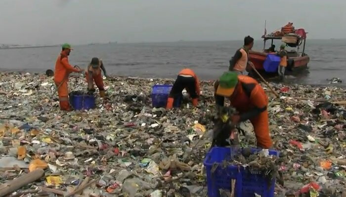 Petugas Sudin LH Kepulauan Seribu membersihkan sampah yang menumpuk di pesisir pantai KBN Cilincing. (deny)