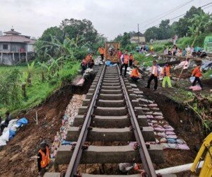 Para pekerja tengah memperbaiki jalur kereta yang terkena dampak longsor. (ist)