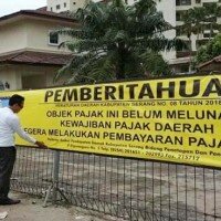 Petugas gabungan memasang spanduk pemberitahuan belum membayar pajak di pagar Hotel Marbella di Jalan Raya Anyer-Cinangka, Desa Bandulu, Kecamatan Anyer. (ist)