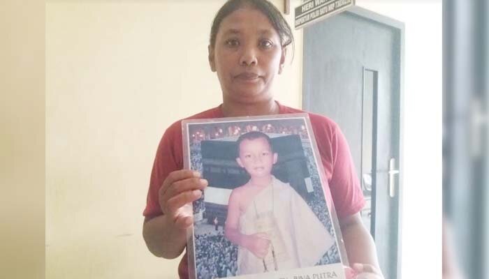 Siti Aminah menunjukkan foto putranya yang hilang.(angga)