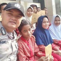 Anggota Bhabinkamtibmas Kelurahan/Kecamatan Cibadak, Brigadir Sandi Praja saat menyantuni anak yatim-piatu.(ist)