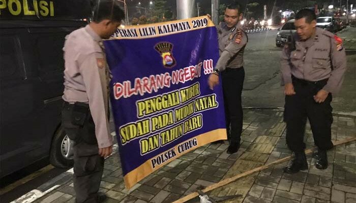 petugas polsek curug memasang spanduk keselamatan berlalu lintas dibeberapa titik rawan kecelakaan. (istimewa)