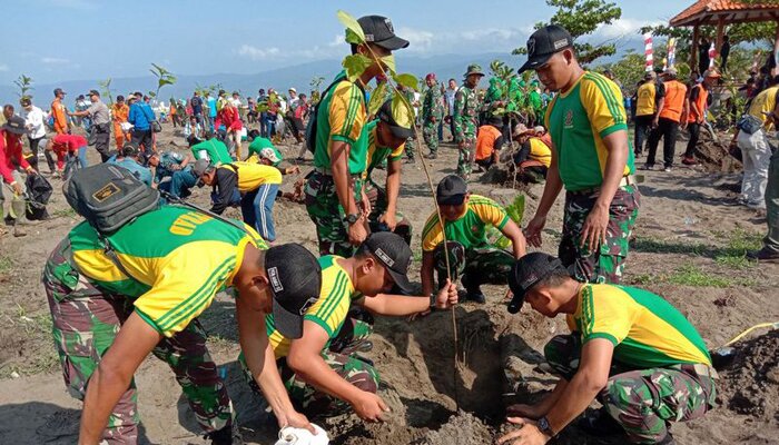 Anggota Yonarmet 13 dan warga bersihkan Pantai Lodjie.(ist)